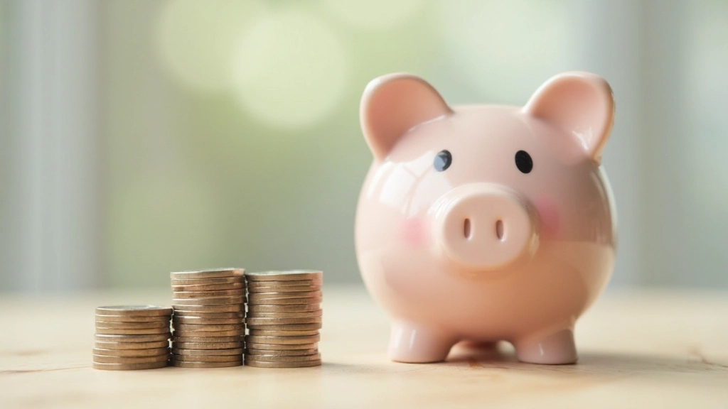 Копилка и монеты на столе, символизирующие накопления